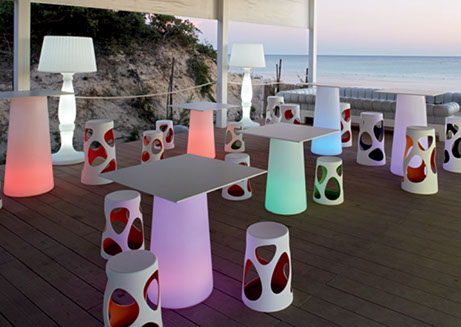 salle avec table design lumineuse et tabourets assortis d'exterieur