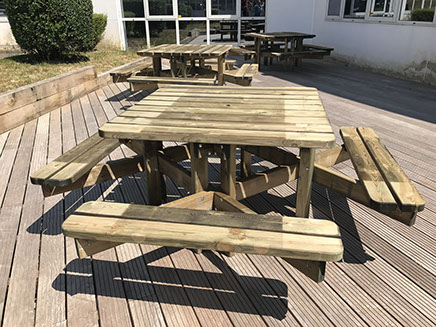 composition sur terasse de table d'exterieur en bois carré avec quatre banc intégrés